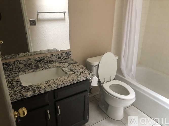 A white toilet sits next to a marble sink in a bathroom.
