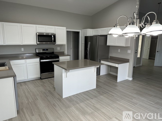A kitchen with white cabinets and a large island.