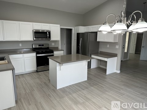 A kitchen with white cabinets and a large island.