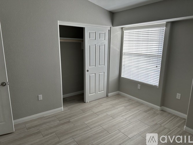 A room with a door and a window with blinds.