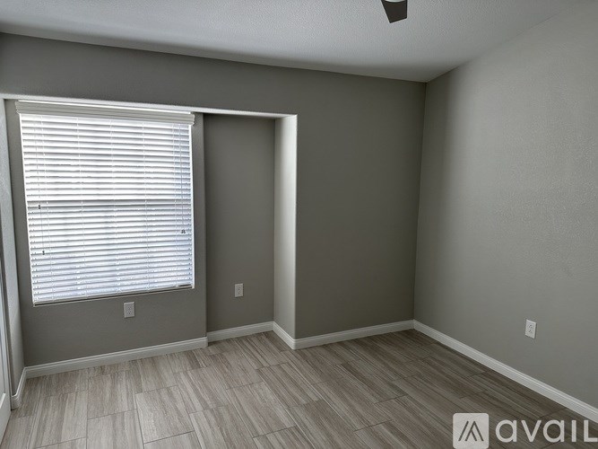 A room with a window and a fan on the ceiling.