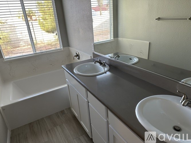 A bathroom with a white tub, sink, and mirror.