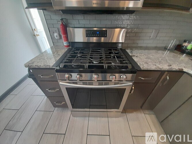 A modern kitchen with a stainless steel range hood and a digital control panel.