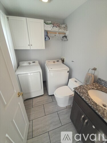 A bathroom with two toilets and a sink.
