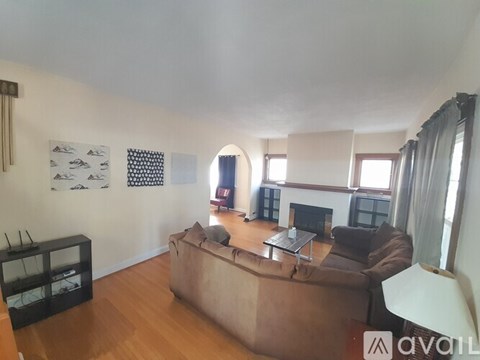 A living room with a brown couch and a fireplace.