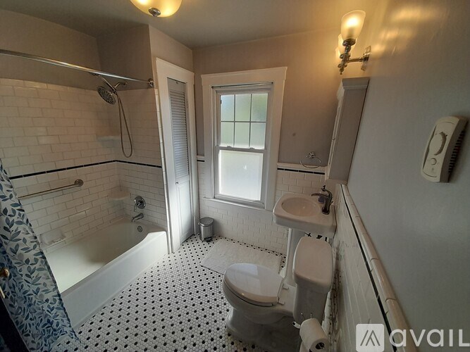 A bathroom with a toilet, sink, and shower.