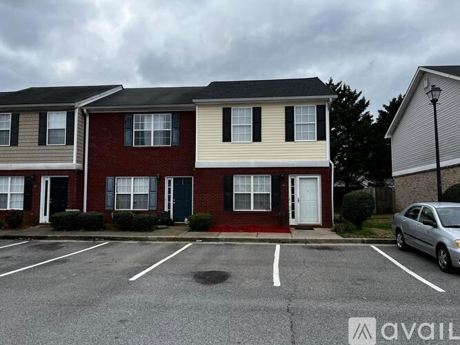 A row of houses with a car parked in front of them.