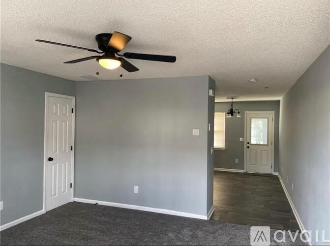 A room with a ceiling fan and two doors.