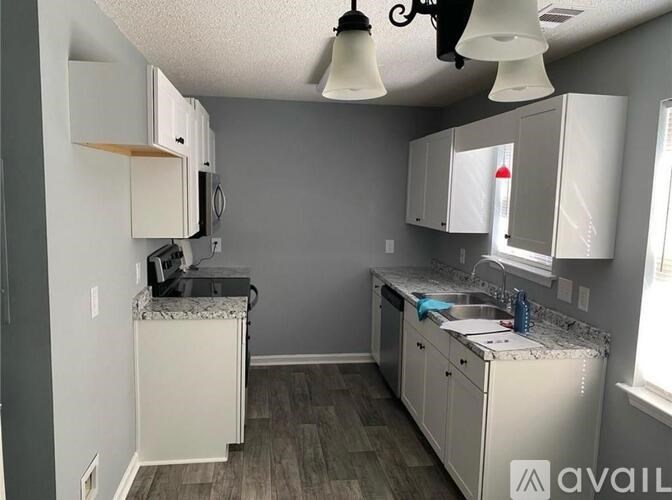A kitchen with white cabinets and a granite countertop.