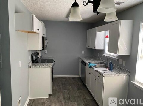 A kitchen with white cabinets and a granite countertop.