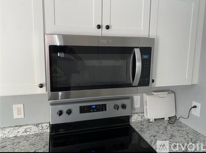 A modern kitchen with a stainless steel oven and microwave.