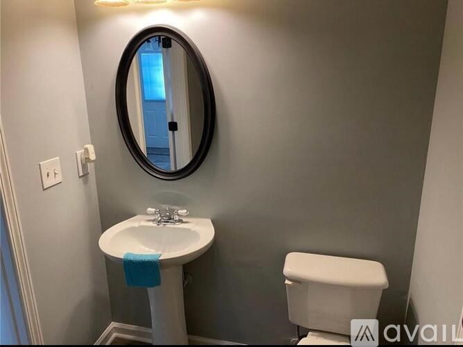 A bathroom with a white sink and toilet.