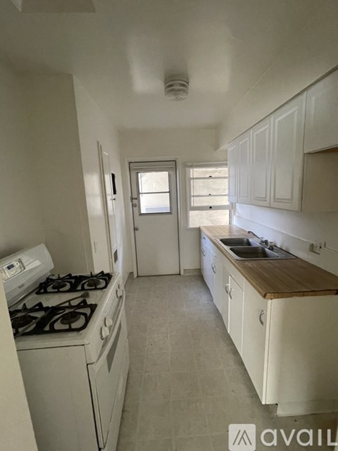A kitchen with white cabinets and a wooden countertop.