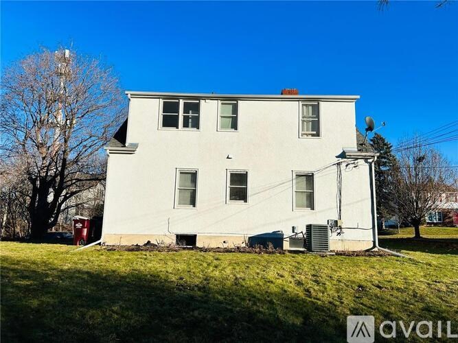 A white house with a red mailbox sits in a grassy field.