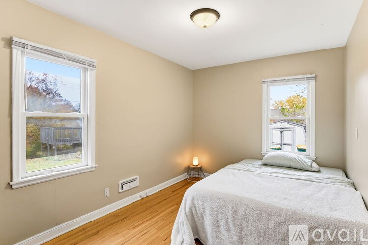 A bedroom with a large bed and a window overlooking a tree-covered hillside.