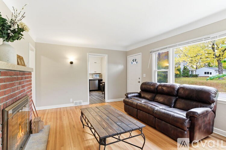 A living room with a brown leather couch and a wooden coffee table.