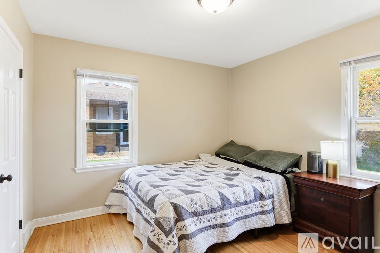 A bedroom with a bed, nightstand, and window.