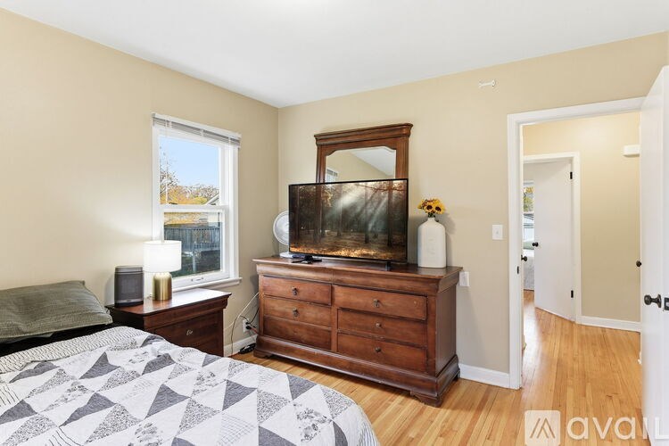 A bedroom with a bed, dresser, and mirror.