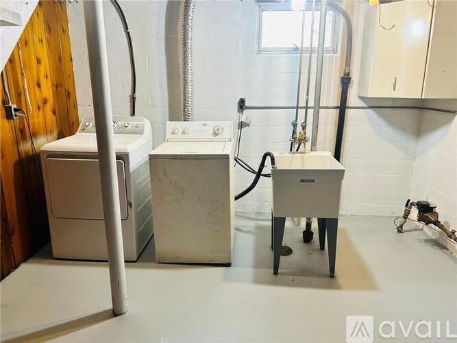 A bathroom with a toilet, sink, and washing machine.