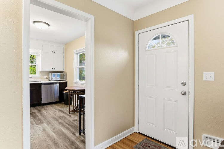 A white door with a glass window is in a room with beige walls.