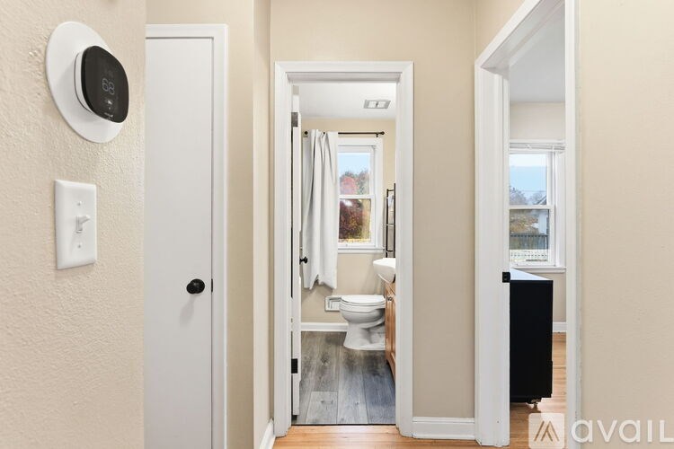 A bathroom with a toilet, sink, and mirror.