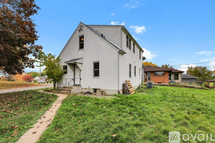 A white house with a green lawn in front of it.