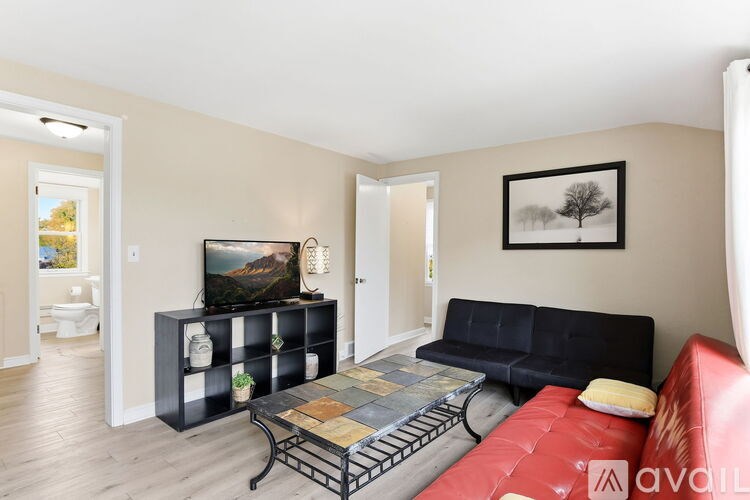 A living room with a red sofa, a black cabinet, and a TV.