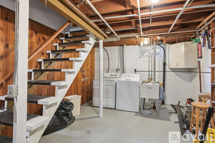 A room with a staircase and a washer and dryer.