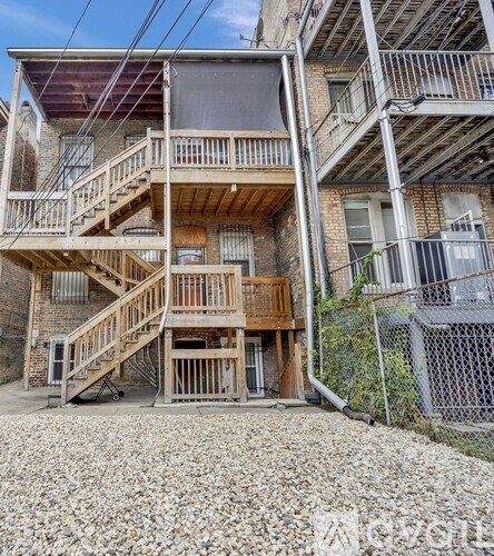 A wooden staircase leads to a balcony in a residential building.