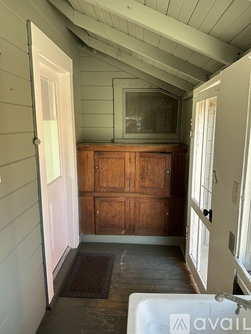 A room with a wooden cabinet and a glass window.