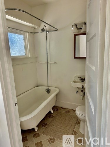 A white bathroom with a tub, toilet and sink.