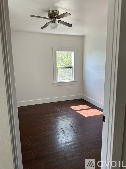 A room with a ceiling fan and a window.