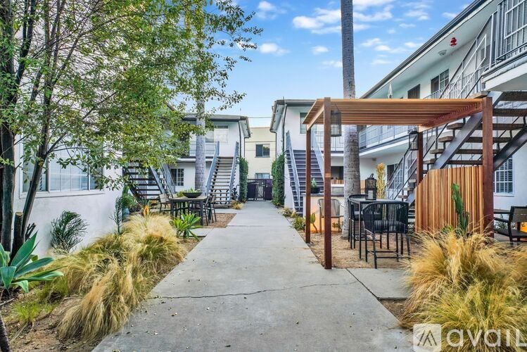 A patio area with a wooden pergola and outdoor furniture.