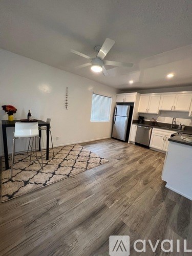 A kitchen with white cabinets and a wooden floor.