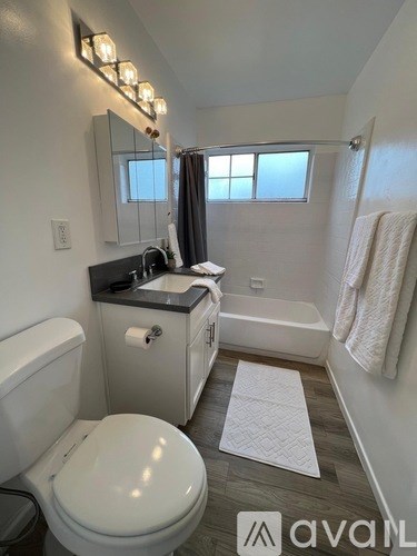 A bathroom with a toilet, sink, and mirror.