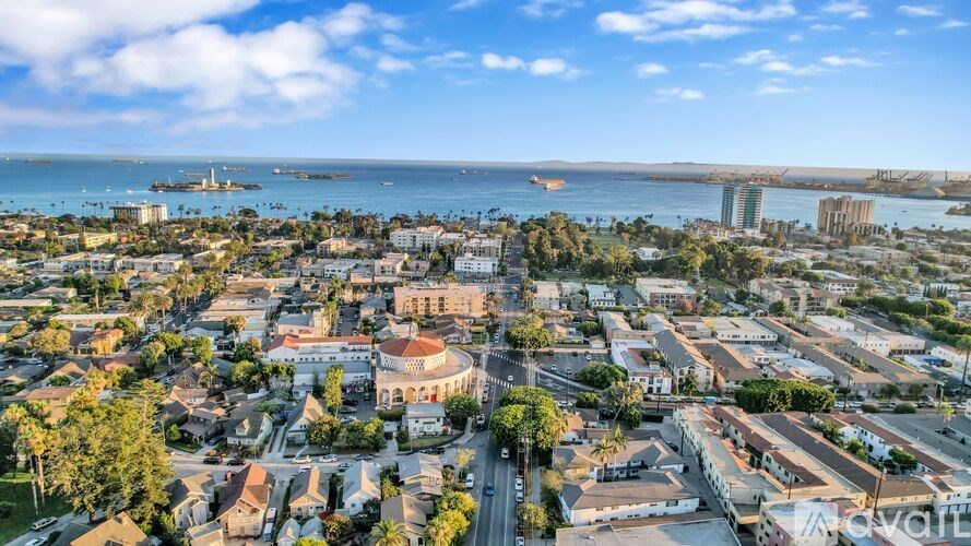 A cityscape with a clear blue sky and a large body of water in the distance.
