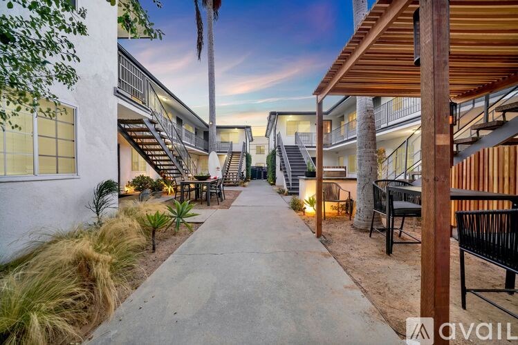A modern outdoor patio area with a wooden pergola and seating area.
