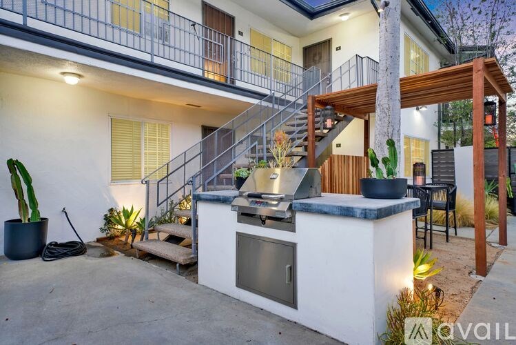 A modern outdoor kitchen area with a grill and seating area.