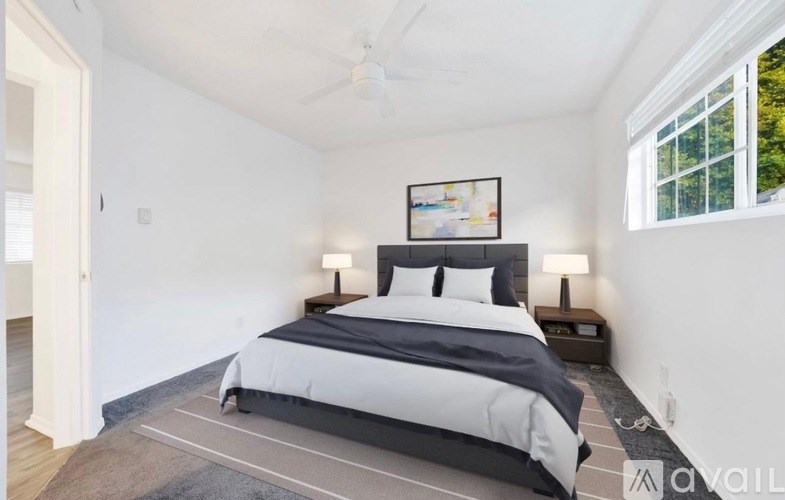 A bedroom with a large bed and a ceiling fan.
