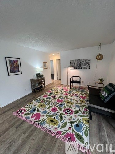 A room with a floral bedspread on the floor.