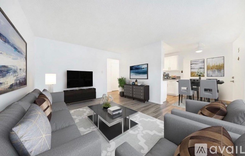 A living room with a grey sofa, a coffee table, and a television.