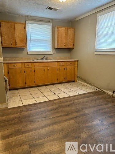 A kitchen with wooden cabinets and a tile floor.