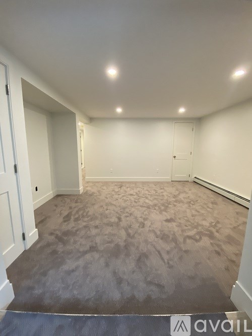 A room with carpeted floor and white walls.