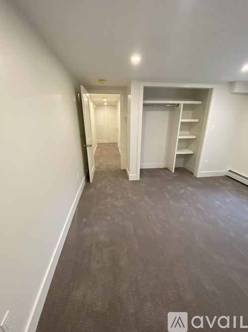 A room with a carpeted floor and a white door.