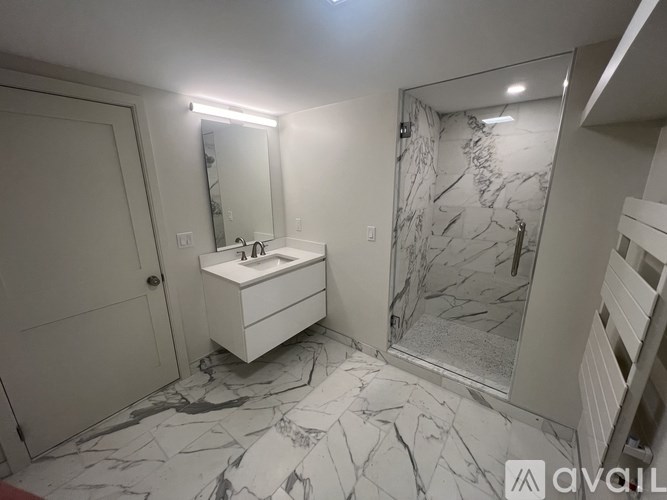 A bathroom with a marble floor and a white sink vanity.