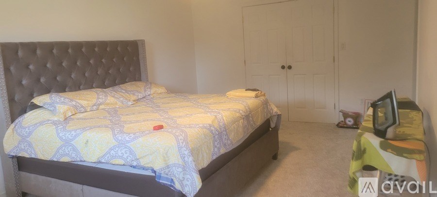 A bedroom with a bed, a dresser, and a wardrobe.