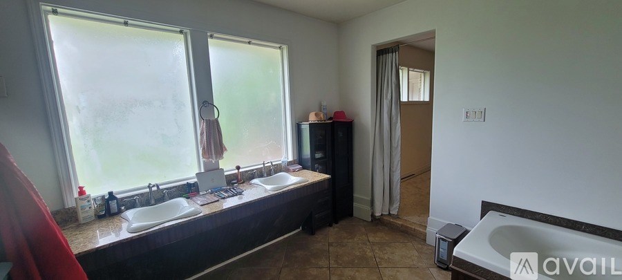 A bathroom with a large window and a bathtub.