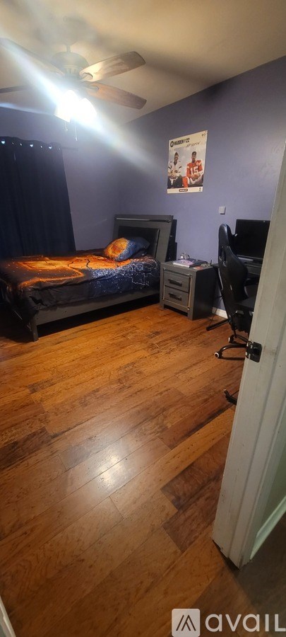 A bedroom with a bed, desk, and chair.