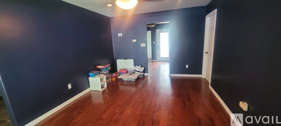 A room with dark blue walls and wooden floors is shown.