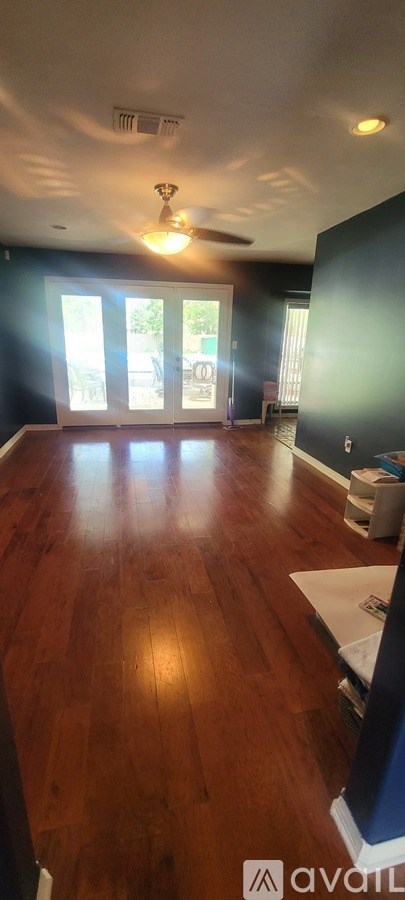 A room with wooden floors and a ceiling fan.